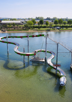 Overzicht strand, meer en waterglijbaan - Villatent Camping Betuwestrand - Beesd, Gelderland, Nederland