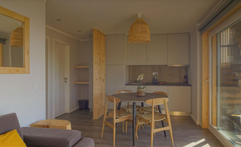 Moderne woon- en keukenhoek in Dome House lodge bij Wecamp Reserva Alecrim, Portugal, met houtaccenten.