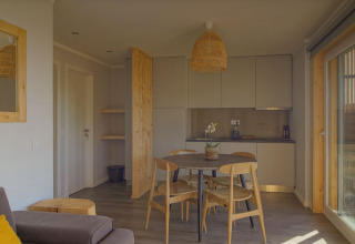 Moderne woon- en keukenhoek in Dome House lodge bij Wecamp Reserva Alecrim, Portugal, met houtaccenten.