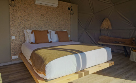 Gezellige slaapkamer met houten accenten in Dome House bij Wecamp Reserva Alecrim in Portugal.