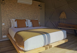 Gezellige slaapkamer met houten accenten in Dome House bij Wecamp Reserva Alecrim in Portugal.