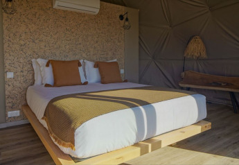 Camera da letto accogliente con letto grande e colori naturali al Dome House, Wecamp Reserva Alecrim, Portogallo.