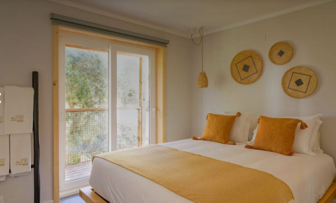 Gezellige slaapkamer in Dome House, Wecamp Reserva Alecrim, Portugal, met modern interieur en grote ramen.