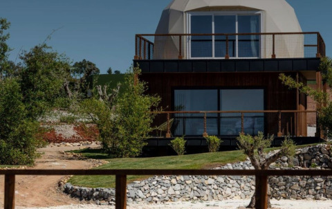 Afbeelding van het Dome House bij Wecamp Reserva Alecrim in Portugal, omgeven door groene natuur en tuin.