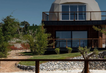Immagine della Dome House al Wecamp Reserva Alecrim in Portogallo, immersa tra alberi e giardini curati.