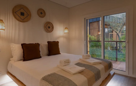 Slaapkamer in Dome House, Wecamp Reserva Alecrim, Portugal, met dubbel bed, sfeerverlichting en terraszicht.