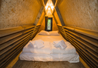 Binnenaanzicht van een luxe safaritent bij Trasimeno Glamping Resort in Italië met royaal houten interieur.