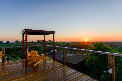 Zonsondergang over glooiende heuvels gezien vanaf het terras bij Family Domes, Wecamp Reserva Alecrim, Portugal.