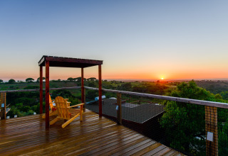 Zonsondergang over glooiende heuvels gezien vanaf het terras bij Family Domes, Wecamp Reserva Alecrim, Portugal.