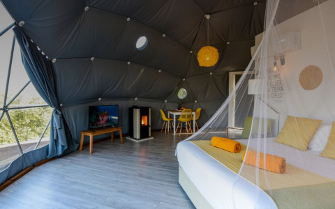 Interieur van Couple Domes bij Wecamp Reserva Alecrim in Portugal, moderne sfeer en gezellig tweepersoonsbed.