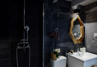 Moderne badkamer met douche, houten omrands spiegel en orchidee in Couple Domes bij Wecamp Reserva Alecrim.