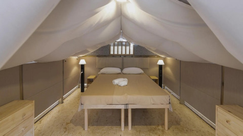Binnenzicht van safari tent Air Lodge 2.0 in Trasimeno Glamping Resort in Italië, met tweepersoonsbed.