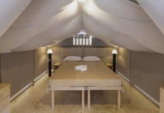 Binnenzicht van safari tent Air Lodge 2.0 in Trasimeno Glamping Resort in Italië, met tweepersoonsbed.