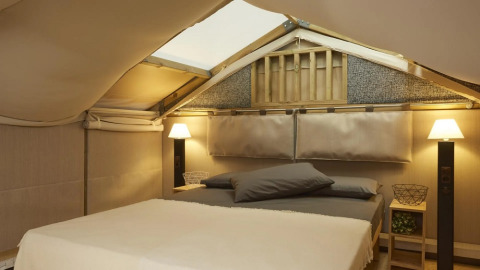 Binnenzicht van safaritent Air Lodge 2.0 bij Trasimeno Glamping Resort in Italië met gezellig bed.