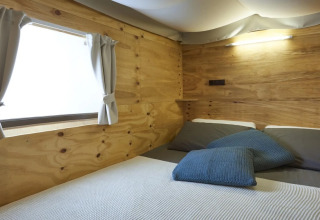 Slaapruimte in de Air Lodge 2.0 safaritent bij Trasimeno Glamping Resort met houten binnenwanden.