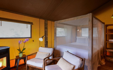 Interieur van safaritent Lodge Family bij Wecamp Reserva Alecrim in Portugal, met bed en stoelen.