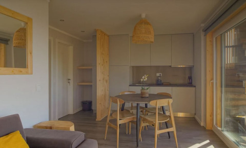 Gezellige woon- en eetruimte in Bungalow Comfort Family van Wecamp Reserva Alecrim, Portugal, met houten meubels.