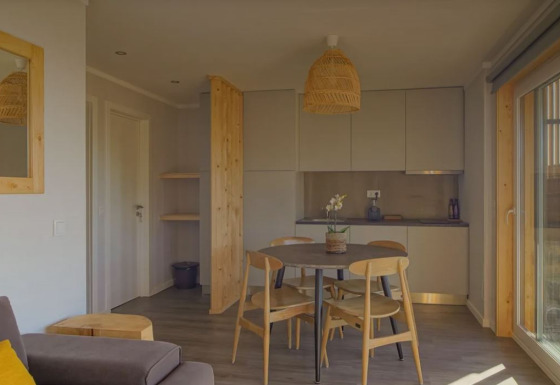 Gezellige woon- en eetruimte in Bungalow Comfort Family van Wecamp Reserva Alecrim, Portugal, met houten meubels.
