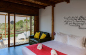 Bungalow «Compact Wood» en Wecamp Reserva Alecrim, Portugal, con cama, sofá y vistas desde el balcón.