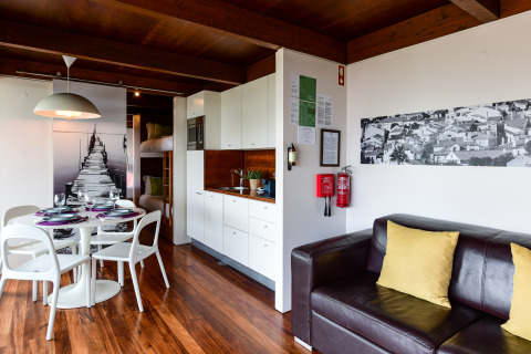 Modern gezinsbungalow interieur bij Wecamp Reserva Alecrim, Portugal met eettafel, keuken en zetel.