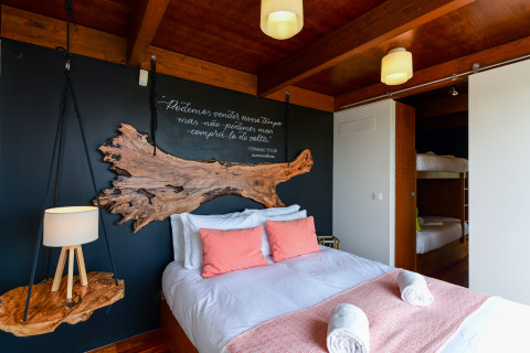 Gezellige slaapkamer in Bungalow Family bij Wecamp Reserva Alecrim in Portugal, met dubbelbed en stapelbedden.