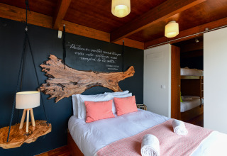 Gezellige slaapkamer in Bungalow Family bij Wecamp Reserva Alecrim in Portugal, met dubbelbed en stapelbedden.