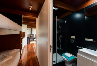 Moderne badkamer en gezellige stapelbedden in een gezinsbungalow bij Wecamp Reserva Alecrim, Portugal.