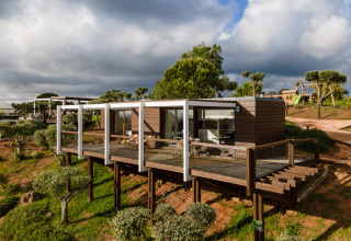 Familiebungalow met veranda en uitzicht, op palen in Wecamp Reserva Alecrim, Portugal, omringd door natuur.