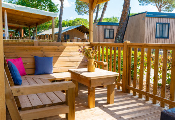 Terraza de madera con asientos y cojines de colores en Cottage Classic, Trasimeno Glamping Resort, Italia.