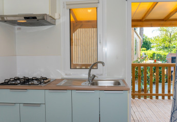 Cocina en Cottage Classic en Trasimeno Glamping Resort, con estufa de gas, fregadero y vista a la terraza.