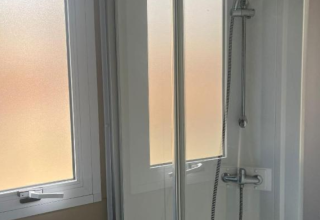 Moderne douche in Bungalow Family Premium te Wecamp Sao Miguel, Portugal, met glazen wand en raam.