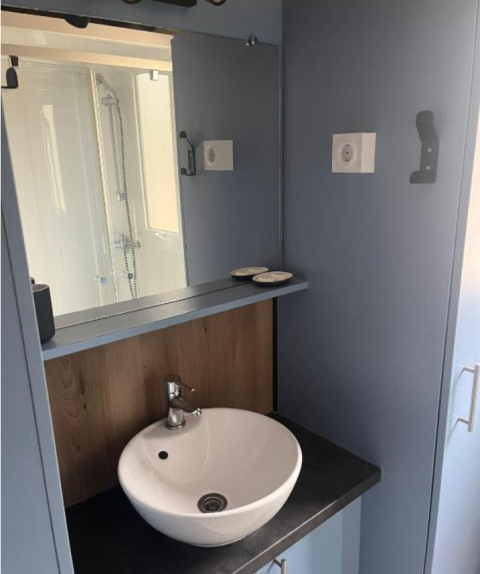 Moderne badkamer met ronde wastafel, spiegel en douche in Bungalow Family Premium, Wecamp Sao Miguel, Portugal.