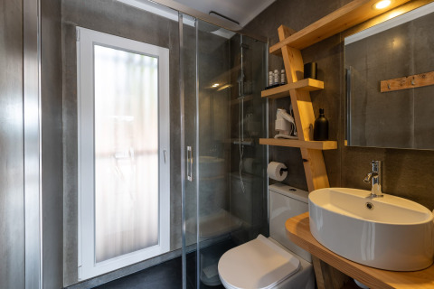 Moderne badkamer met glazen douche, houten rek en ronde wasbak bij Dome House Duplex Do Lago in Portugal.
