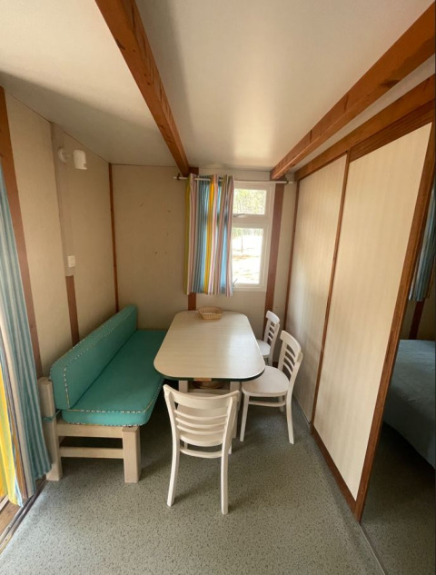 Eethoek van Bungalow Basic Family bij Wecamp Sao Miguel, Portugal, met tafel, stoelen en zitbank.
