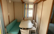 Spisestue i Bungalow Basic Family på Wecamp Sao Miguel, Portugal, med bord, stole og bænk.