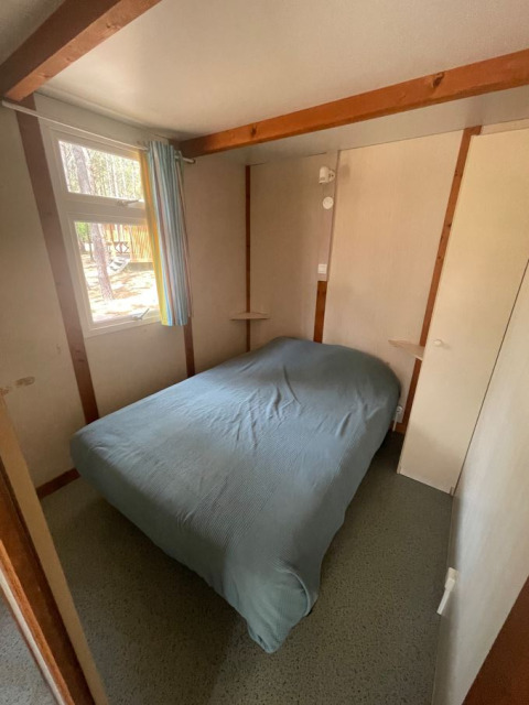 Slaapkamer van Bungalow Basic Family bij Wecamp Sao Miguel in Portugal, met een tweepersoonsbed en raam.