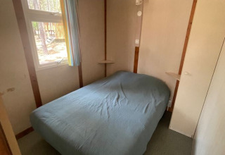 Slaapkamer van Bungalow Basic Family bij Wecamp Sao Miguel in Portugal, met een tweepersoonsbed en raam.