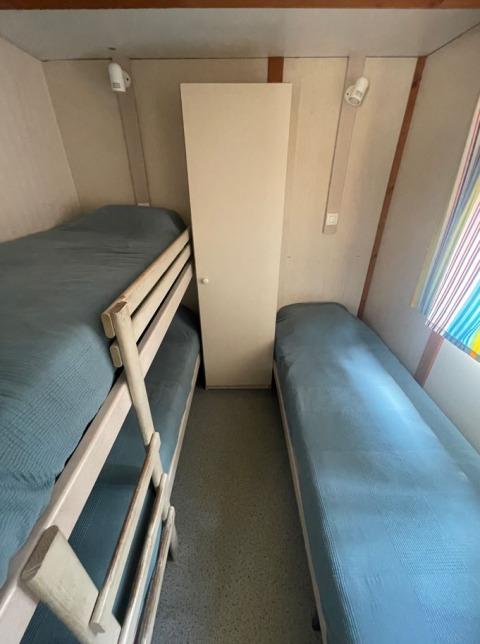 Kleine kamer in Bungalow Basic Family bij Wecamp Sao Miguel met stapelbed, eenpersoonsbed en kast.