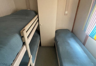 Kleine kamer in Bungalow Basic Family bij Wecamp Sao Miguel met stapelbed, eenpersoonsbed en kast.