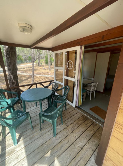 Houten terras met groene stoelen en tafel aan Bungalow Basic Family bij Wecamp Sao Miguel, Portugal.