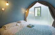 Interno di una tenda safari Coco Suite al Lake Trasimeno Glamping Resort in Italia con letto.