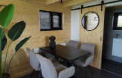 Zona pranzo di Tiny House 2+2 a Hindeloopen, Paesi Bassi, con pareti in legno e arredamento moderno.