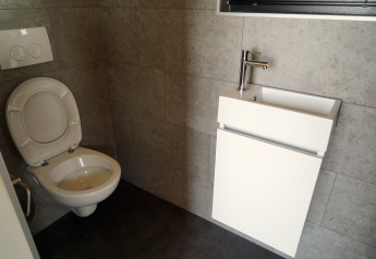 Modern small bathroom in Tiny House 2+2, Hindeloopen, Netherlands, featuring a toilet and sink.
