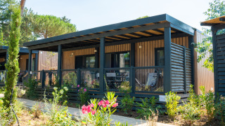 Moderne houten vakantiewoning met grote overdekte veranda en tuin bij Cottage Next XXL Prestige.