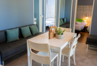 Sala moderna con mesa de comedor y sofá en Cottage Next XXL Prestige en Trasimeno Glamping Resort, Italia.