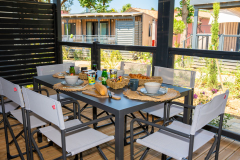 Mesa de desayuno al aire libre con pan, zumo y café en Cottage Next XXL Prestige, Trasimeno Glamping Resort, Italia.