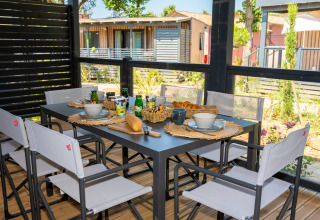 Mesa de desayuno al aire libre con pan, zumo y café en Cottage Next XXL Prestige, Trasimeno Glamping Resort, Italia.