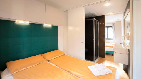 Camera da letto del Cottage Next XL Panorama presso Trasimeno Glamping Resort, Italia, con arredo moderno.