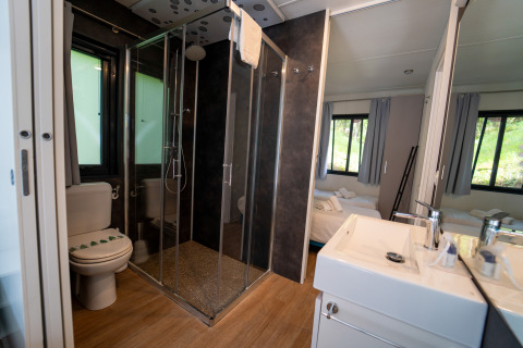 Bagno moderno con box doccia, wc e lavabo al Cottage Next XL Panorama, Trasimeno Glamping Resort, Italia.