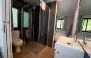 Bagno moderno con box doccia, wc e lavabo al Cottage Next XL Panorama, Trasimeno Glamping Resort, Italia.
